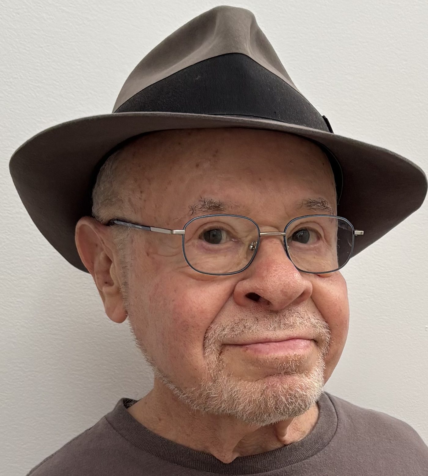 Frank S. Joseph smiling in a gray felt fedora with a black band